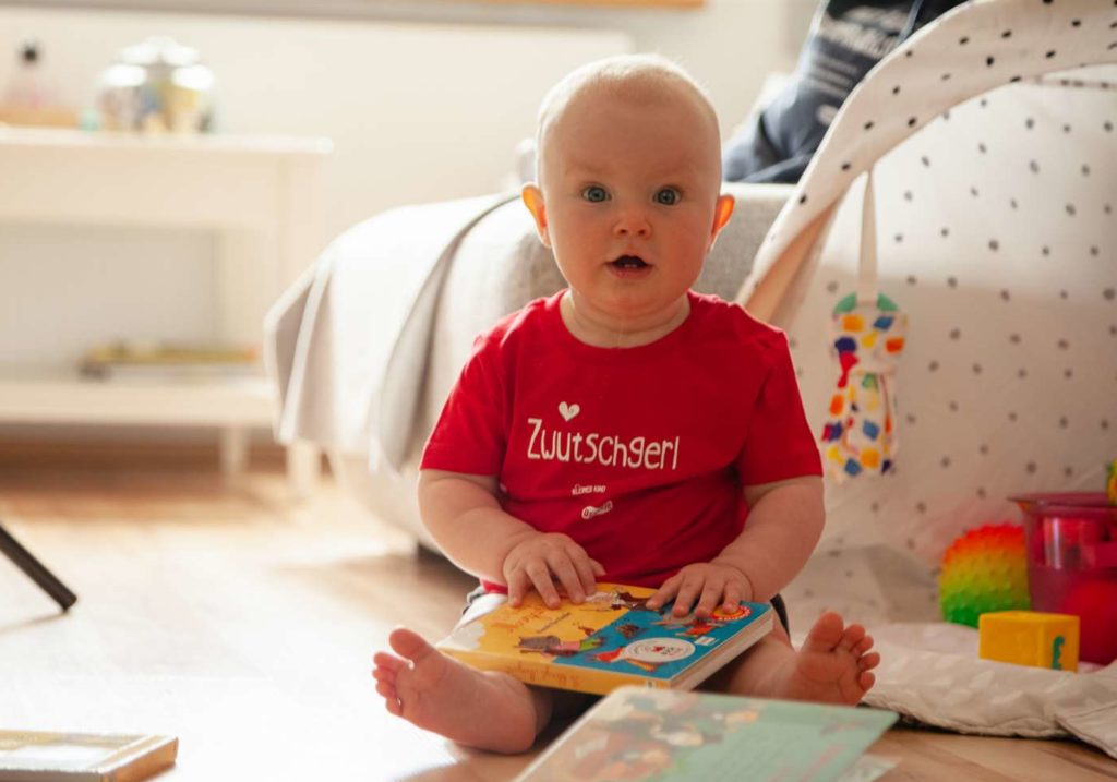 Ostseele-Zwutschgerl-Baby-spielt-mit-einem-Buch